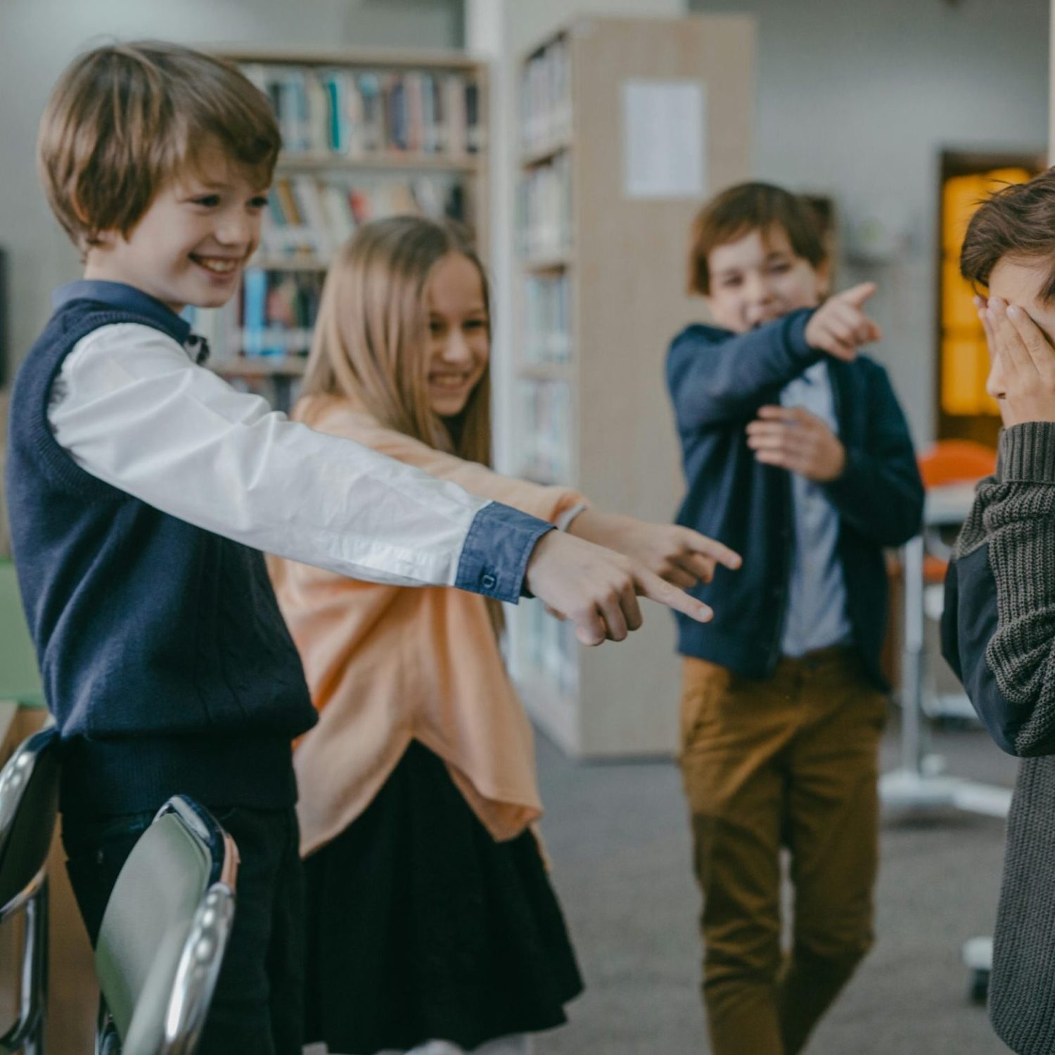 Group of children bullying a classmate in a school library setting.